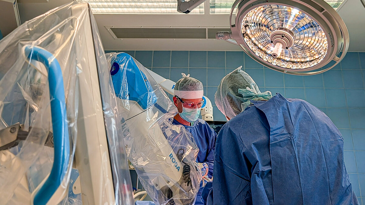 Chefarzt PD Dr. Markus Bormann (l.) und ltd. Oberarzt Dr. Tilman Eßlinger (r.) bei einer roboterassistierten Knieersatz-OP. | © Foto: Dominique Roth| Kliniken Ostallgäu-Kaufbeuren